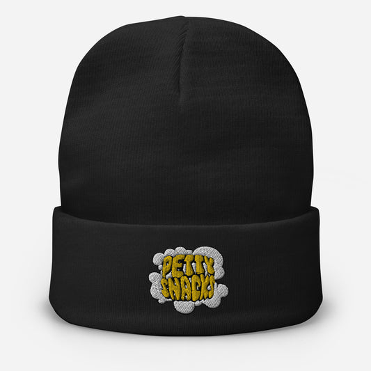 A black cuff beanie, embroidery on front center. Embroidery of white smoke cloud, yellow lettering in cloud reads "Petty Snacks" with a black outline.